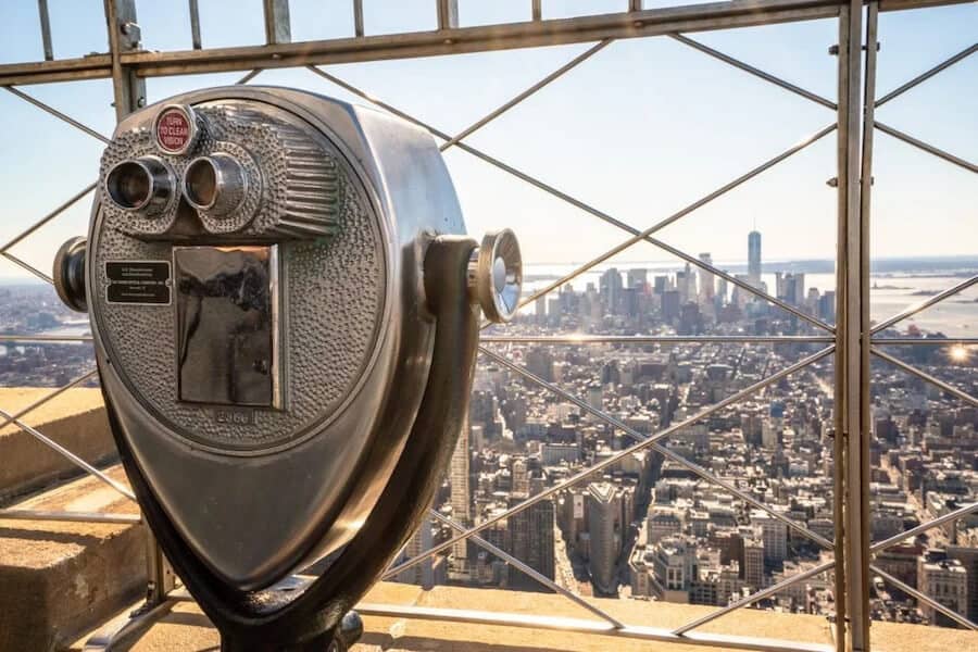 Observation deck in New York City with tourist telescope overlooking the sprawling NYC cityscape