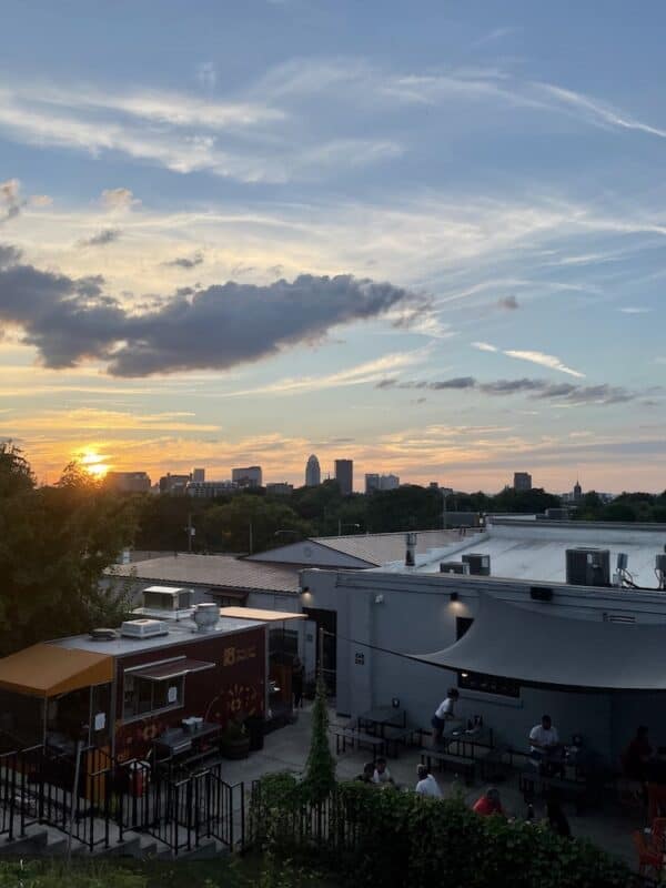 The Louisville skyline seen from a brewery with a food truck and patio tables
