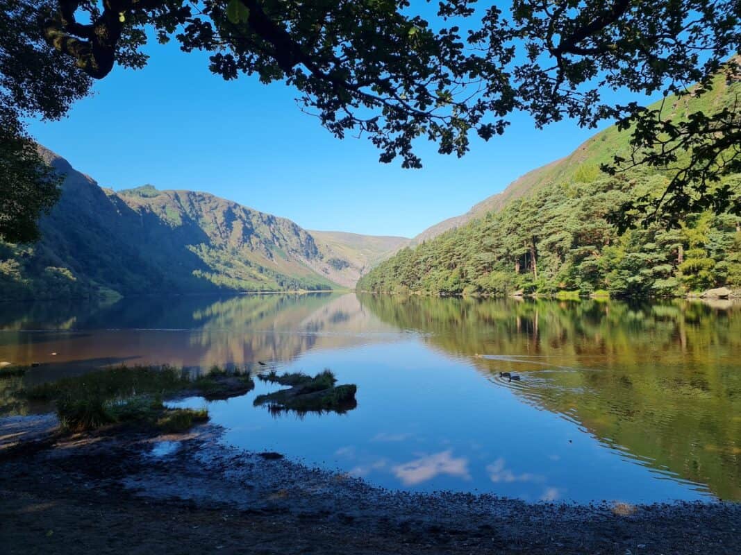 Glendalough Upper Lake surrounded by tree-lined hills