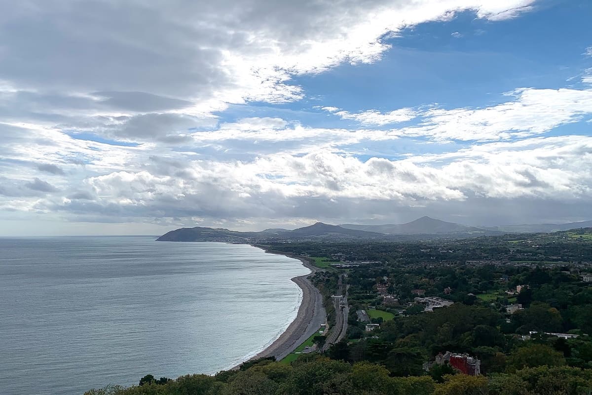 A view of the town of Killiney seen from Killiney Hill Park, with the ocean and coastline on the left and Wicklow Mountains in the background
